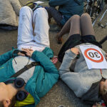 Due manifestanti sdraiate sull'asfalto